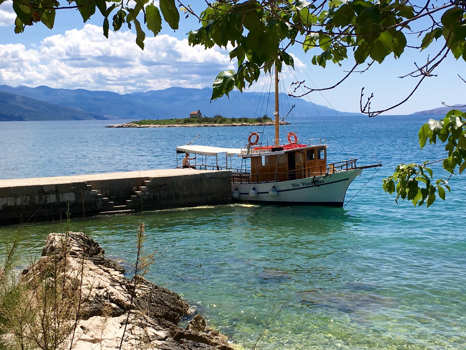 Tour boat sailing near the cliffs of Vrbnik, Croatia